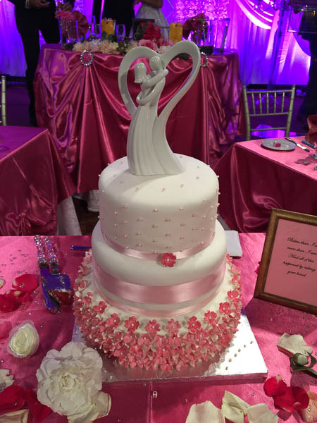 A beautiful (and delicious!) wedding cake is displayed on stage.